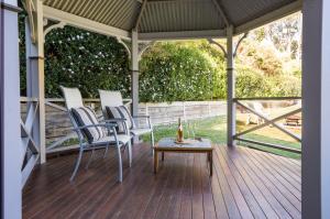a porch with chairs and a table on a deck at Cosy Romantic Lodge, Perfect Couples Getaway in Sassafras