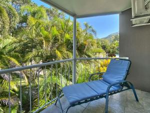 a blue chair on a balcony with palm trees at Island Magic Townhouse 5 in Arcadia