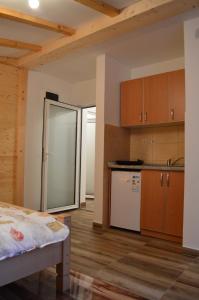 uma cozinha com frigorífico e armários de madeira em Apartments Grbović em Žabljak