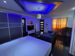 1 dormitorio con cama blanca y techo azul en Grosvenor Square Kandi Realty, en Ángeles