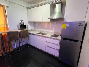cocina con armarios morados y nevera en Grosvenor Square Kandi Realty, en Ángeles 7 fotos más