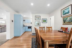 een eetkamer en een keuken met een houten tafel en stoelen bij The Abbey in Point Lonsdale +12 foto's