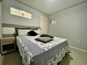 a bedroom with a bed with two pillows on it at Casa 2 Suítes+1 - VISTA MAR e 15km do Beto Carrero - 50 metros da PRAIA - Area de LAZER com Churrasqueira - Wi-Fi e Cozinha Completa in Piçarras