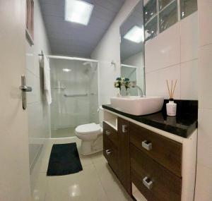 a bathroom with a toilet and a sink and a shower at Casa 2 Suítes+1 - VISTA MAR e 15km do Beto Carrero - 50 metros da PRAIA - Area de LAZER com Churrasqueira - Wi-Fi e Cozinha Completa in Piçarras +36 photos