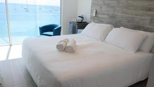 una camera da letto con un letto bianco con asciugamani sopra di One Love Motel a Gros Islet