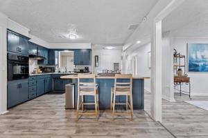 a kitchen with blue cabinets and a island with bar stools at Affordable 5br Near Route 66 Large Groups #12 in Oklahoma City