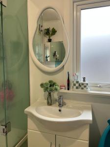 a bathroom with a sink and a mirror at MKM Villa - Cozy House in Central Lower Hutt in Lower Hutt