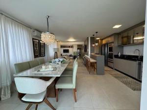 a dining room and kitchen with a table and chairs at Bali Beach Home Club - Resort à Beira-Mar in Piçarras