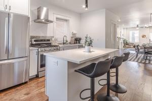 a kitchen with a white counter and chairs in it at Ann Avenue Spacious 3BR Home with Games, Yard and Near Downtown in Saint Louis