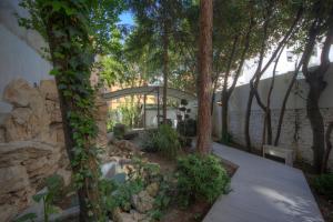 un jardín con árboles y una pared de piedra en Astoria Golden House, en Roma