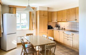 a kitchen with a table and a white refrigerator at Cozy Home In Hok With Wifi in Hok