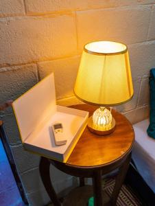 Una mesa con una lámpara y un teléfono encima. en Casa DUNA 4, en La Libertad