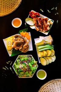 a table topped with different types of food on plates at Du Yen Garden Mang Đen in Kon Von Kla