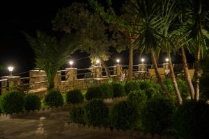 a patio at night with palm trees and lights at Guesthouse Enastron in Chorefto