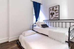 two twin beds in a room with a window at Ann Avenue Charming 3 Bedroom Retreat Near Downtown St Louis in Saint Louis