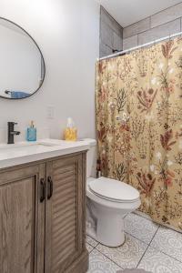 a bathroom with a toilet and a shower curtain at Ann Avenue Charming 3 Bedroom Retreat Near Downtown St Louis in Saint Louis +32 photos