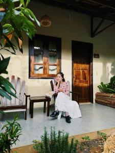 a woman sitting in a chair on a porch at Du Yen Garden Mang Đen in Kon Von Kla