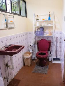 Un baño con un inodoro rojo y un lavabo. en Casa DUNA 2, en La Libertad