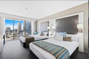 two beds in a hotel room with a large window at Private Hotel Rooms in Central Surfers in Gold Coast