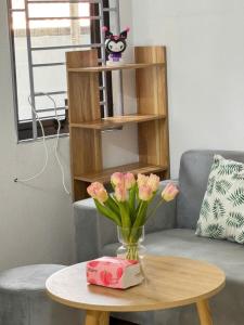 a table with a vase with pink flowers on it at Someli in Hanoi