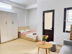 a bedroom with a bed and a table with a vase of flowers at Someli in Hanoi