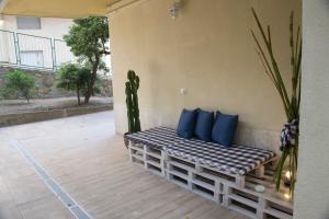 un banco con almohadas azules sentado en un patio en semeria103, en San Remo