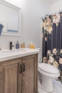 a bathroom with a sink and a toilet and a shower curtain at Ann Avenue Modern 3BR Home, Near Downtown with Free Parking in Saint Louis