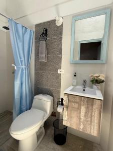 a bathroom with a toilet and a sink and a window at Encanto Azul in Villa de Leyva