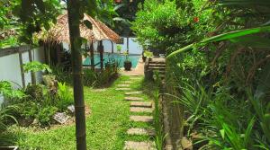 a garden with a path leading to a pool at Guesthouse Thalassa in Bunaken