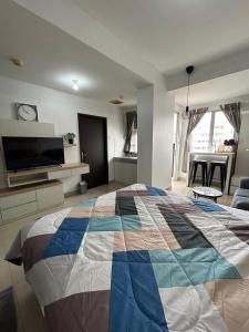 a bedroom with a large bed and a living room at 1BR Plus Sudirman Suite Apart by Metta in Bandung