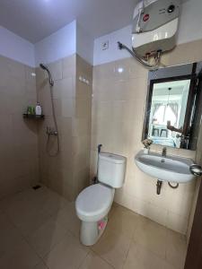 a bathroom with a toilet and a sink at 1BR Plus Sudirman Suite Apart by Metta in Bandung