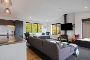 a living room with a couch and a tv at Family Size Holiday Home With Remarkable Views & Sauna, Close to Town in Queenstown