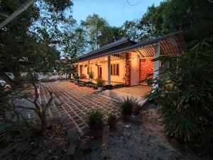 a house with a brick walkway in front of it at Angel Homestay Paravoor in Alleppey