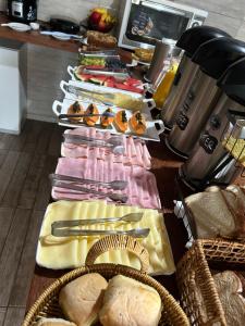 a table with different types of cheese and bread at Canoa Abraão in Abraão