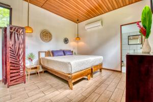 um quarto com uma cama e um espelho em Beachfront Studio - Direct Beach Access, Fast Wifi & AC em Puerto Viejo
