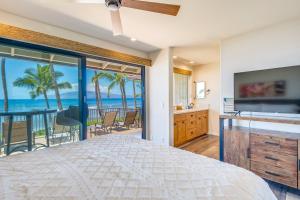 a bedroom with a bed and a view of the ocean at Puamana 240-3 in Lahaina