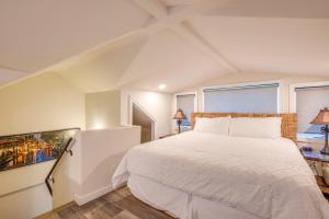 a bedroom with a white bed and two windows at Puamana 240-3 in Lahaina