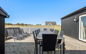 a table and chairs on a patio with a view of the ocean at Awesome Home In Ringkøbing With Sauna in Ringkøbing +16 photos