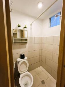 a small bathroom with a toilet and a sink at BGC Suites Uptown in Makati