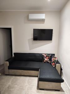 トリノにあるCasa Madaの薄型テレビ付きの客室で、黒いソファが備わります。