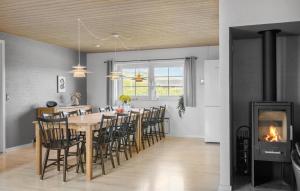 a dining room with a table and chairs and a fireplace at Gorgeous Home In Harboøre With Sauna in Harboør