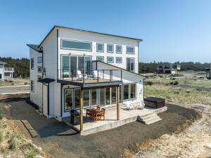 a house with a large deck with a table at The Beachcomber - Oceanfront Getaway! in Westport