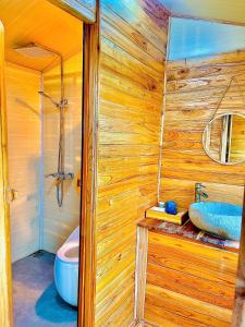 a bathroom with a wooden wall with a sink and a toilet at Khu sinh thái Ecolodge Kê Nênh Điện Biên in Ban Hin Lom +112 photos