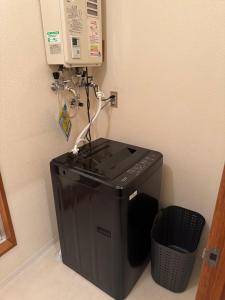 a machine in a corner next to a trash can at STAY Moiwayama in Sapporo