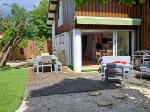 d'une terrasse avec des chaises et une table dans l'arrière-cour. dans l'établissement Maison de vacances climatisée avec JACUZZI proche du Lac - FR-1-831-12, à Biscarrosse 12 autres photos