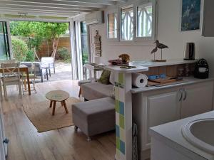 una cucina e un soggiorno con un divano e un tavolo di Maison de vacances climatisée avec JACUZZI proche du Lac - FR-1-831-12 a Biscarrosse