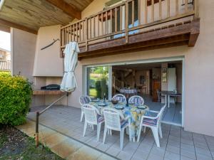 a table with chairs and an umbrella on a patio at Spacieuse maison 3 chambres à Biscarrosse pour 6 personnes - FR-1-319-610 in Biscarrosse