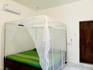 a bed with a canopy in a room at The Woodnest in Arugam Bay