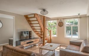 a living room with a staircase and a television at Oud Kempen Bungalow 41 in Stavenisse