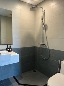 a bathroom with a shower and a toilet and a sink at Honeymon vinhomes grand park - 3 phòng ngủ in Gò Công +25 photos